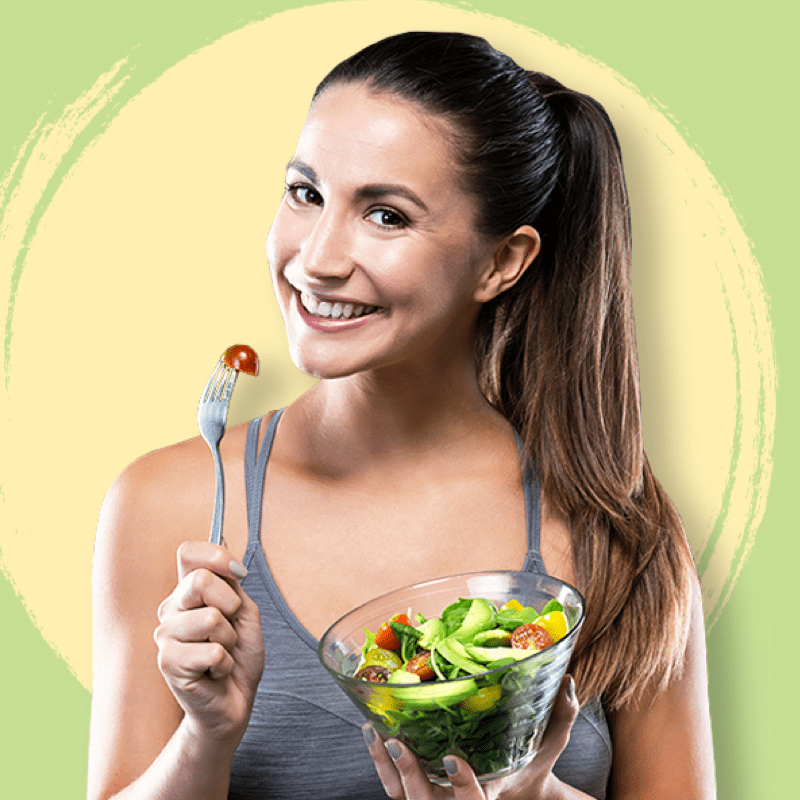 A woman holding a bowl of salad and smiling.