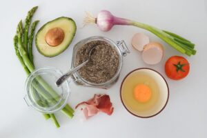 A table topped with eggs, avocado and other food.